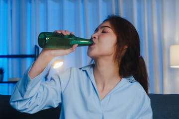 Девушка пьет алкоголь из бутылки